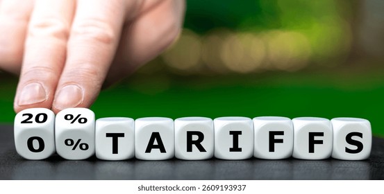 Hand turns dice and changes the expression '0 percent tariffs' to '20 percent tariffs'. Symbol for the US tariffs on European goods. 