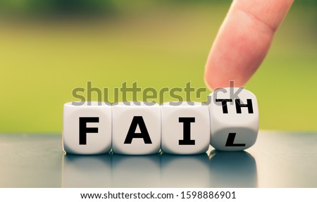 Hand turns a dice and changes the expression "fail" to "faith", or vice versa.