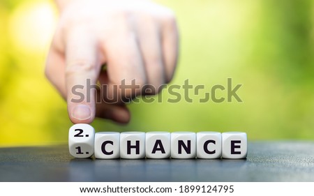 Hand turns dice and changes the expression "1. chance" to "2. chance".