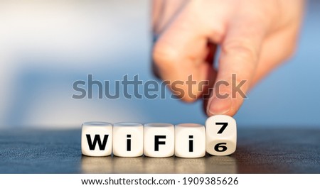 Hand turns dice and changes the expression "WiFi 6" to "WiFi 7".
