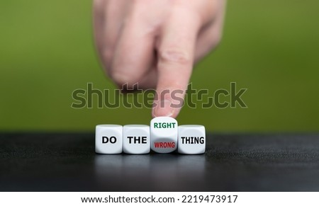 Hand turns dice and changes the expression 'do the wrong thing' to 'do the right thing'.
