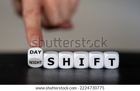 Hand turns dice and changes the  expression 'day shift' to 'night shift'.