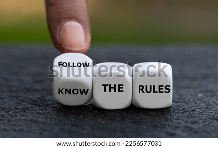Hand turns dice and changes the expression 'know the rules'. to 'follow the rules'.