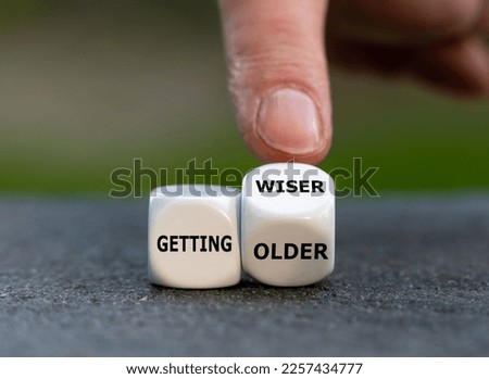 Hand turns dice and changes the expression 'getting older' to 'getting wiser'.