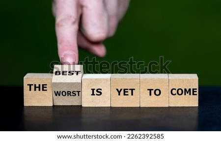 Hand turns dice and changes the expression 'the worst is yet to come' to 'the best is yet to come'.