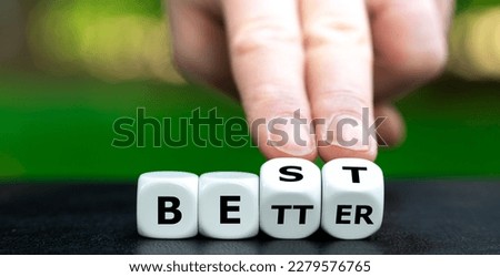 Hand turns dice and changes the expression 'better' to 'best'.