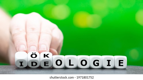 Hand turns dice and changes the German word "Ideologie" (ideology) to "Ökologie" (ecology).  - Shutterstock ID 1971801752
