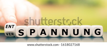 Hand turns a dice and changes the German word 