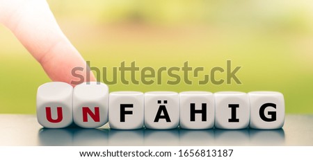 Hand turns dice and changes the German word 