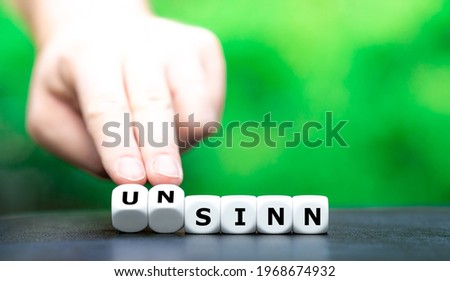 Hand turns dice and changes the German word 