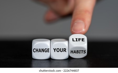 Hand turns dice and changes the slogan 'change your habits' to 'change your life'. - Shutterstock ID 2226744837