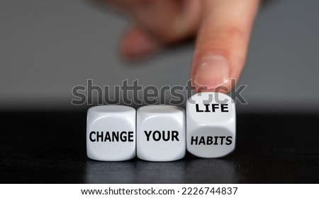 Hand turns dice and changes the slogan 'change your habits' to 'change your life'.
