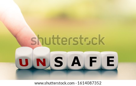 Hand turns dice and changes the word unsafe to safe.