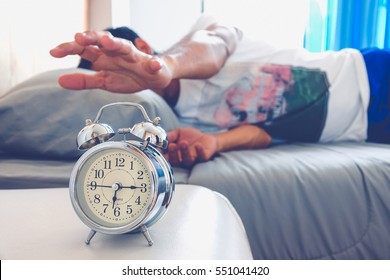 Hand turns off the alarm clock waking up at morning . soft skin tone effect