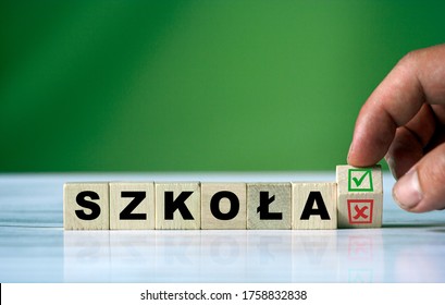 The hand turns the wooden cube and changes the polish word SZKOŁA (english = school) with green positive tick check box and red reject X check box. - Shutterstock ID 1758832838
