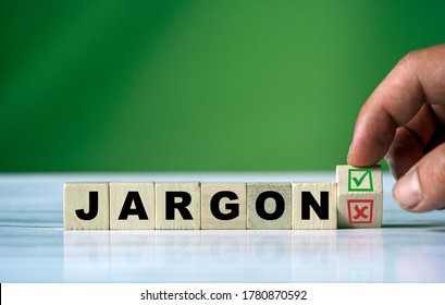 The hand turns the wooden cube and changes the word JARGON with green positive tick check box and red reject X check box.