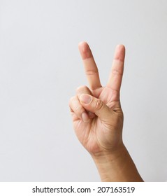 Hand with two fingers up in the peace or victory symbol. Also the sign for the letter V in sign language. Isolated on white.