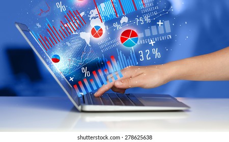 Hand typing on modern laptop notebook computer with future graph icons and symbols  - Powered by Shutterstock