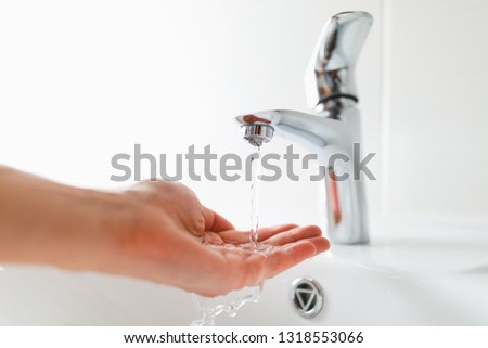hand under faucet with water stream