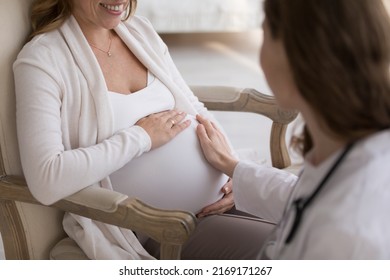 Hand Of Unknown Obstetrician Touches Big Belly Of Pregnant Woman During Visit At Home, Close Up Cropped Shot. Prenatal Care, Doula Consults Future Mother, Pregnancy, Motherhood And Medicine Concept