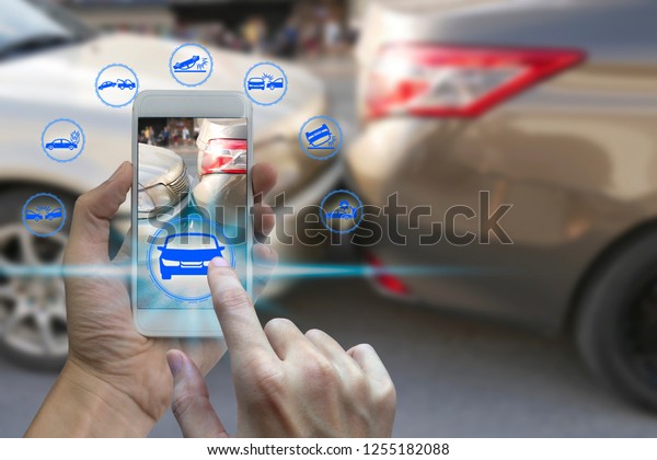 Hand use smartphone with car claim icons over\
the Network connection on car crash background, car accident for\
car insuranc claim\
concept.\
