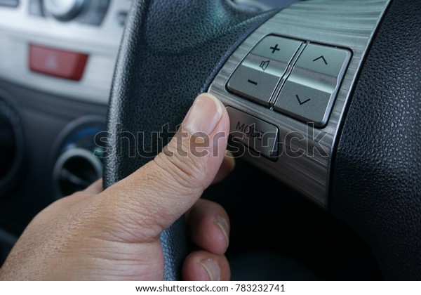 hand using audio system controller\
switch on steering wheel to change radio system\
mode