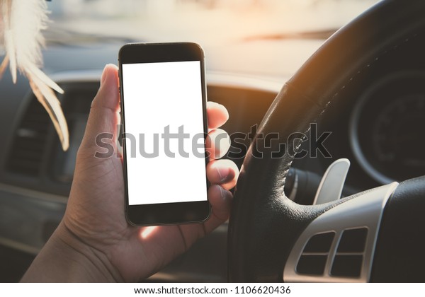 Hand\
using blank white screen mobile smartphone inside a car in sunny\
day, copy space for your app or product\
display,