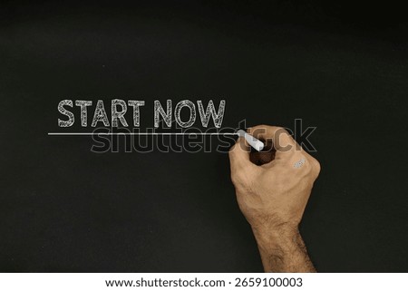 Hand Using Chalk Writing Start Now on Blackboard Background for Motivation
