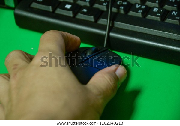 a hand using a\
computer mouse  and keyboard 