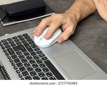 Hand Using Computer Mouse Next to Laptop Keyboard