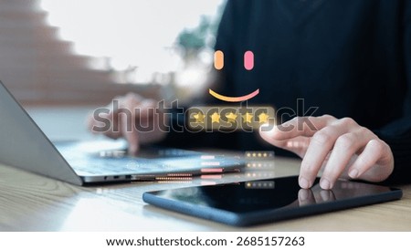 Hand using digital device with smiley face and five-star rating, customer satisfaction, online review, user feedback, and business service quality concept.