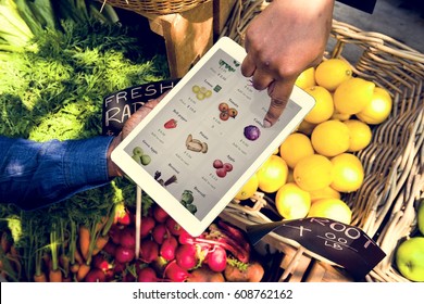 Hand using digital tablet in aerial view on vegetable and fruit