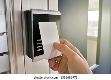 Hand using Key card at RFID card reader for open the door ;access control concept