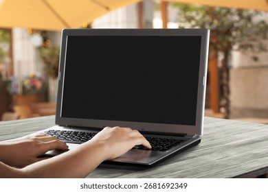 Hand using laptop computer with blank screen