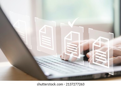 Hand using laptop computer with virtual screen and document for online approve paperless quality assurance and ERP management concept.