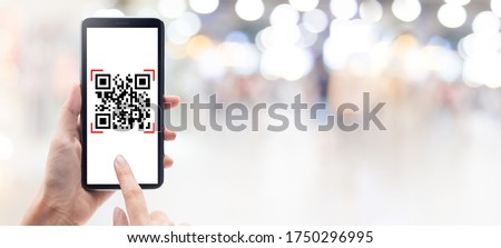 Hand using mobile smart phone scan Qr code on shopping mall banner background. Barcode reader, Qr code payment, Cashless technology, Digital money concept.