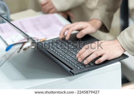 Employee’s hand  using office computer Typing an email on a computer keyboard and doing online research working in an office.