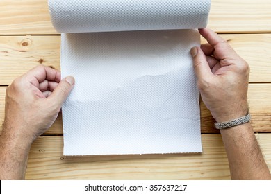 Hand Using A Paper Towel On A Wooden Desk