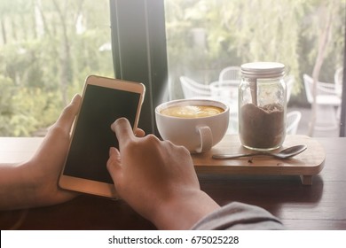 hand using phone in cafe.