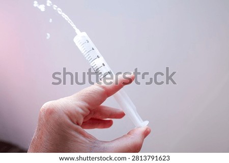 Hand Using Plastic Syringe Expelling Liquid – Medical Concept