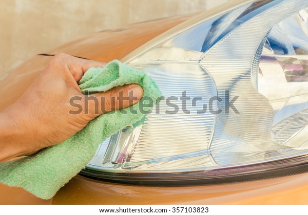 Hand is using a polishing cloth clean the\
car, Car cleaning\
background.