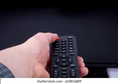 Hand Using A Remote Control In Front Of The TV Screen