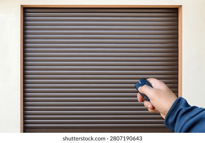  Hand Using Remote to Open Roller Shutter Garage Door 