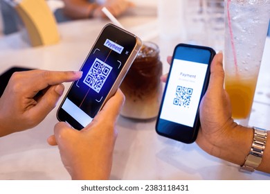 Hand using smart phone to scan QR code on tag with blurry soft drink  and customers in cafe or restaurant to accepted generate digital pay without money. Qr code payment concept. - Powered by Shutterstock