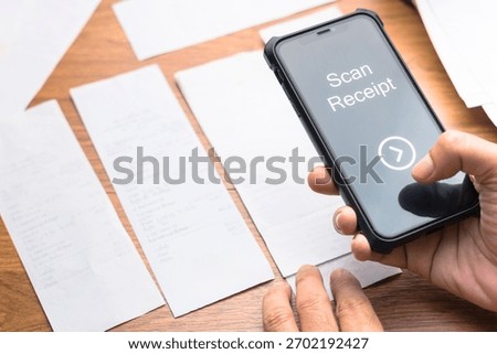 Hand using smart phone to scan and manage paper receipts for budgeting, expense tracking, and tax deduction