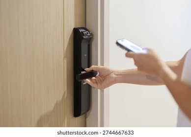 Hand using smartphone for close or Open digital door lock at home or apartment. NFC Technology, Fingerprint scan, keycard, PIN number, smartphone, electrical and contactless lifestyle concepts