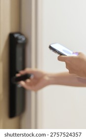 Hand using smartphone for close or Open digital door lock at home or apartment. NFC Technology, Fingerprint scan, keycard, PIN number, smartphone, electrical and contactless lifestyle concepts