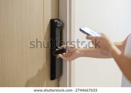 Hand using smartphone for close or Open digital door lock at home or apartment. NFC Technology, Fingerprint scan, keycard, PIN number, smartphone, electrical and contactless lifestyle concepts