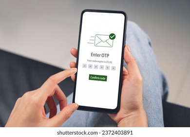 Hand using smartphone and mobile OTP secure verification on send to email with enter password for login banking account on on desk.