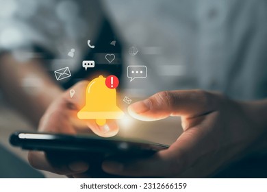 Hand using smartphone with showing the bell icon and notifications of new messages on application. - Shutterstock ID 2312666159